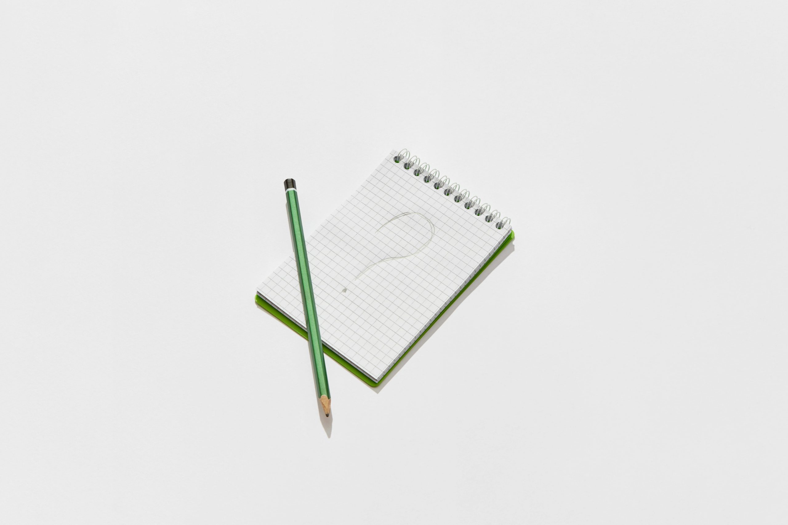 a pen and note pad with a question mark, representing the question, should you sell your business?